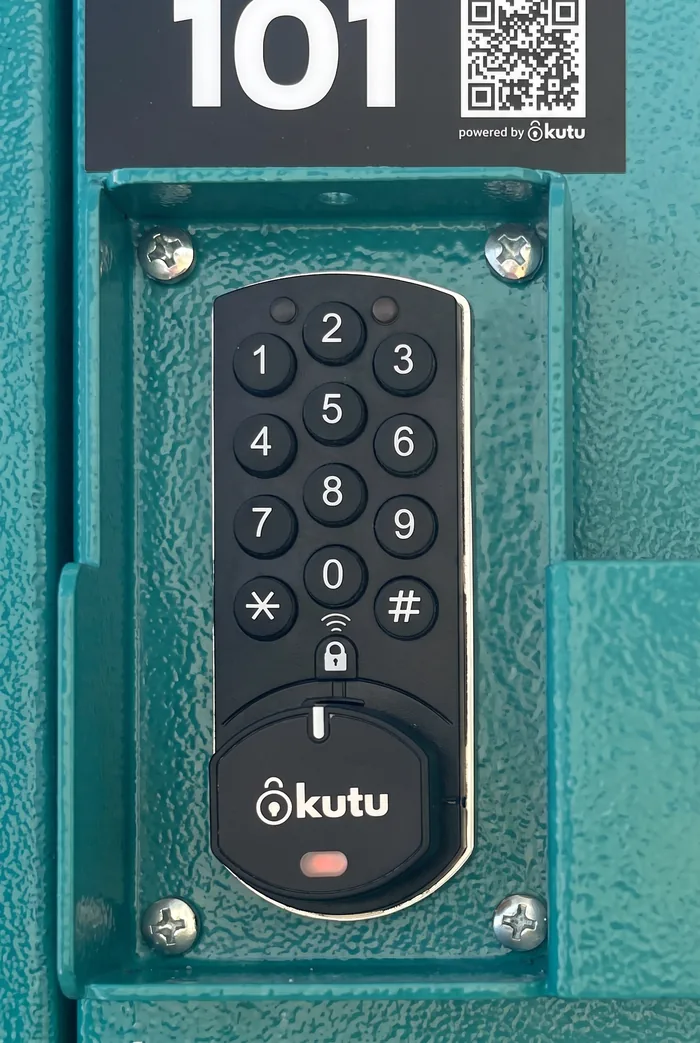 Close-up of the black Kutu keypad on the teal locker door, where the door code is typed.